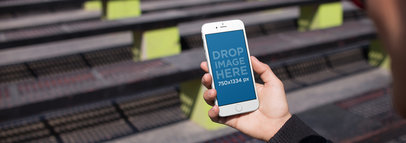 Over Shoulder Template of a Girl Holding a White iPhone 6 While Looking at Several Benches a14213wide