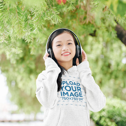 Pullover Hoodie Mockup Featuring a Teenage Girl Listening to Music