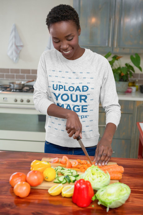 Crewneck Sweatshirt Mockup of a Young Woman Cutting Vegetables