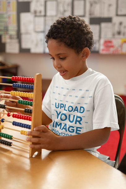 T-Shirt Mockup Featuring a Boy with an Abacus at School