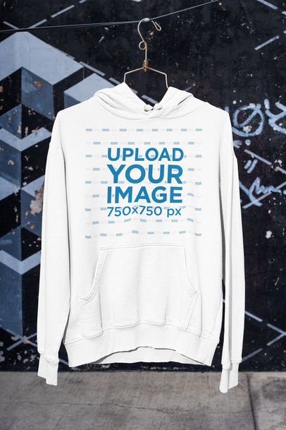 Mockup of a Pullover Hoodie Placed on a Hanger by a Street