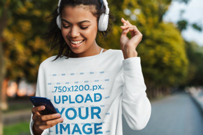 Sweatshirt Mockup Featuring a Young Woman Listening to Music While Walking