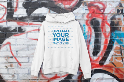 Mockup of a Hoodie Hanging on a Graffiti Wall m460