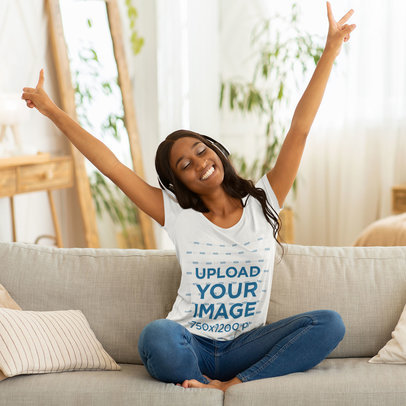 T-Shirt Mockup Featuring a Joyful Woman Listening to Music on Her Couch 