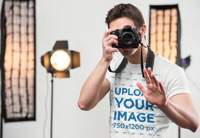 T-Shirt Mockup of a Man Taking a Photograph with a Professional Camera 