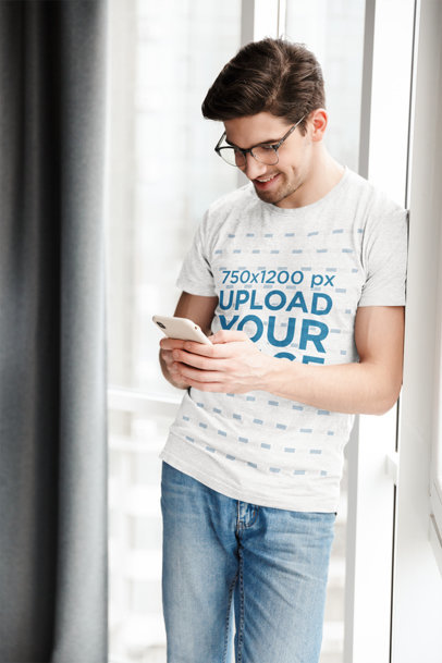 Heathered T-Shirt Mockup of a Happy Man Texting 