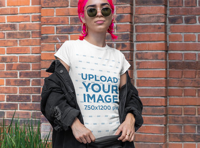 T-Shirt Mockup of a Woman With Pink Hair Posing by a Brick Wall