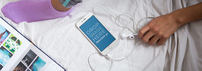 Girl With a White iPhone 6 Mockup Lying on a Bed With Headphones and a Book a14260wide