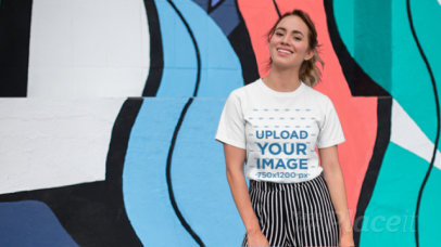 Tee Parallax Video of a Smiling Woman in Front of a Wall with Colorful Illustrations