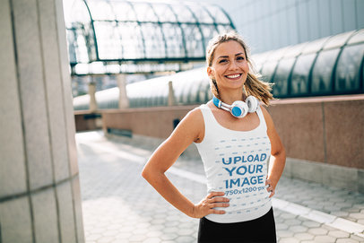 Mockup of a Happy Woman With Headphones Wearing a Tank Top in the City 