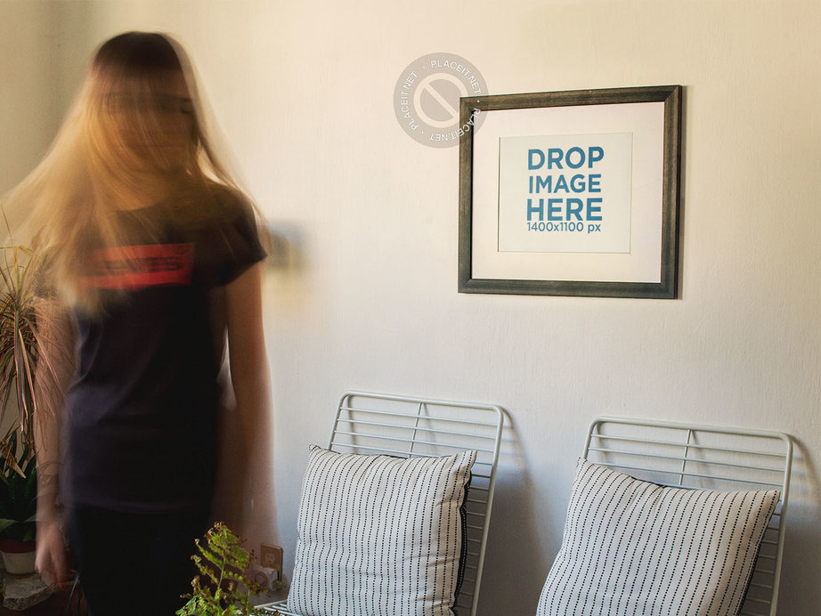 Blonde Woman Moving Her Hair While a Framed Art Print Template is on a White Wall