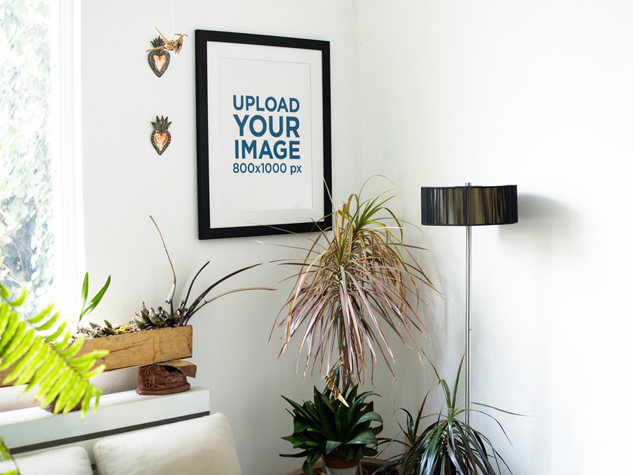 Young White Woman Sitting Down Inside a Waiting Room While a Framed Art Print Template is on the Wall