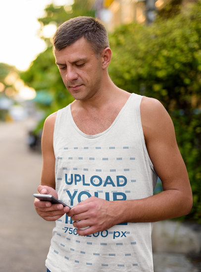 Tank Top Mockup of a Serious Man Checking His Phone