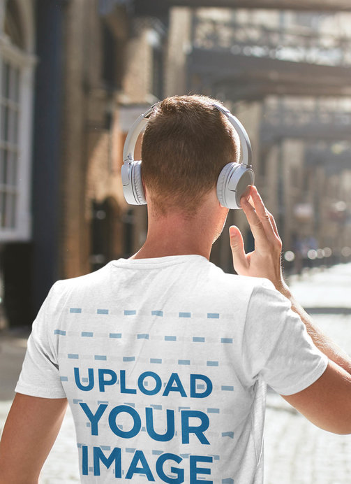 T-Shirt Mockup of a Man Walking Down The Street with Headphones On