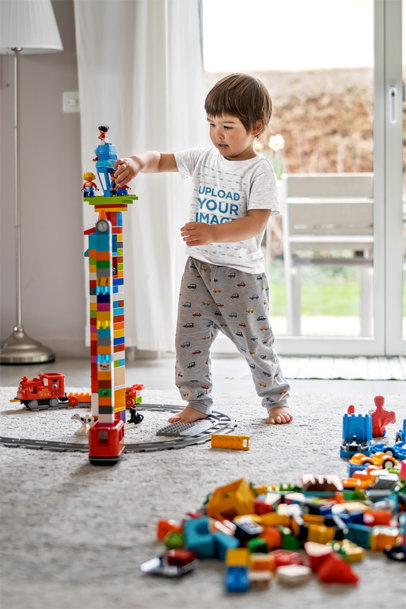 T-Shirt Mockup of a Little Boy Playing with Toys in His Room