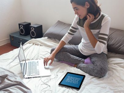 Mockup of a Young Woman Using Her Laptop on her Bed with Her iPad by Her Side 14261