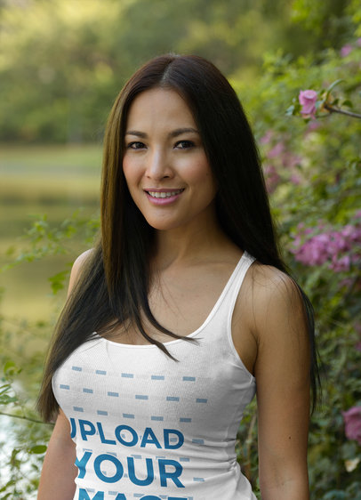 Tank Top Mockup of a Woman with Long Hair Posing by a Flower Bush