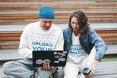 Sweatshirt Mockup Featuring a Couple Looking at Their Laptop 
