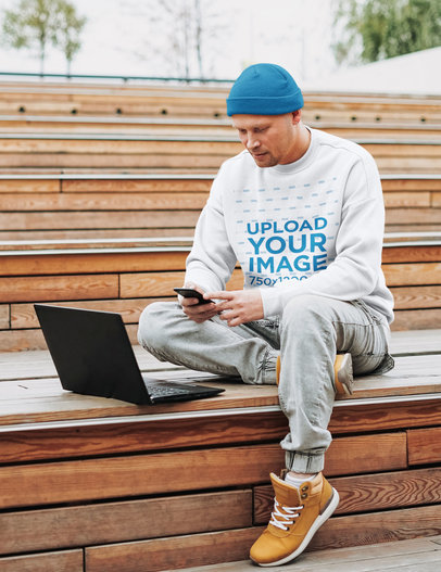 Sweatshirt Mockup of a Man Working Outside with His Laptop
