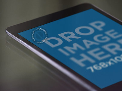 Close Up Mockup of an Angled Black iPad Mini Lying Over a Glass Table