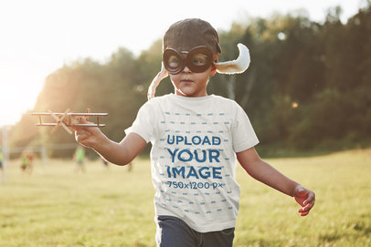 T-Shirt Mockup Featuring a Little Boy Playing With an Airplane Toy 