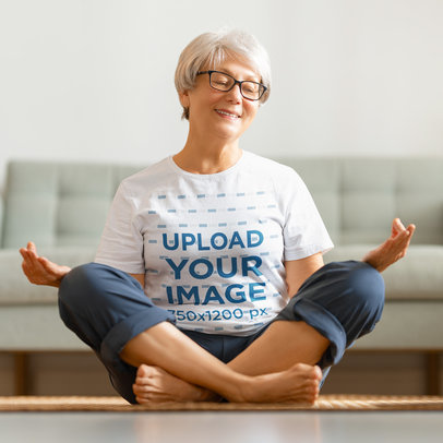 T-Shirt Mockup Featuring a Happy Senior Woman Meditating at Home 