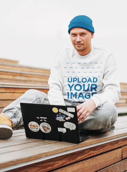 Sweatshirt Mockup Featuring a Man Working on His Laptop 