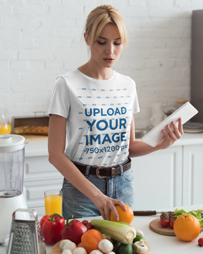T-Shirt Mockup of a Woman Making a Salad in Her Kitchen