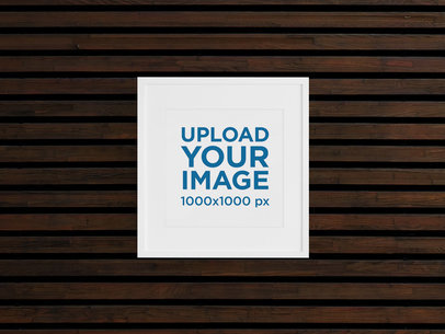 Mockup Featuring a Framed Square Art Print Hanging on a Wooden Wall 