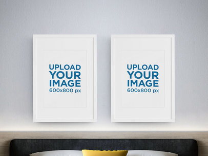 Mockup of Two Vertical Art Prints Hanging on a Bedroom's Wall