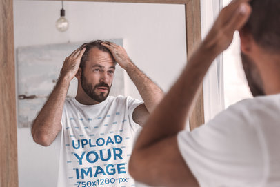 T-Shirt Mockup of a Man Looking at Himself in a Mirror