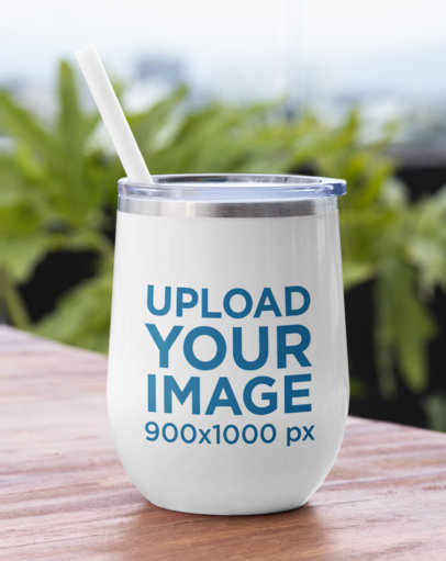 Mockup of a Wine Tumbler Placed on a Wooden Table 