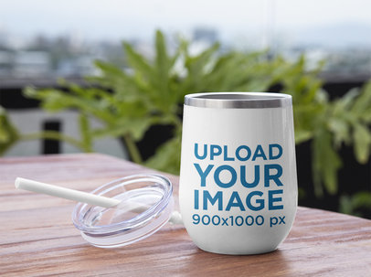 Mockup of a Wine Tumbler and its Lid on a Wooden Table 