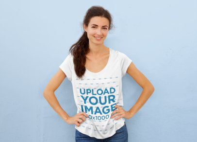 T-Shirt Mockup of a Woman Standing Against a Plain Wall