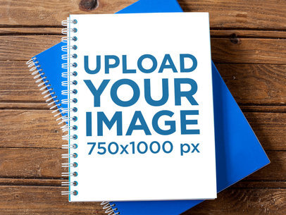 Spiral Notebook Template Lying Over Another Blue Notebook on a Wooden Surface