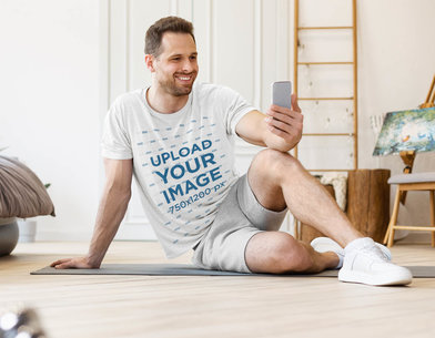 T-Shirt Mockup of a Man on a Video Call While Working Out at Home