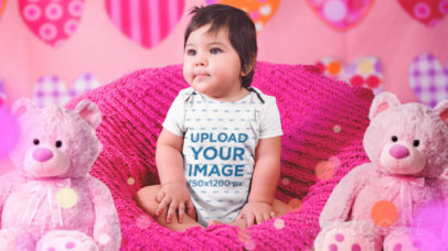 Parallax Video of a Little Baby Girl Sitting On A Pink Sofa While Wearing A Onesie 