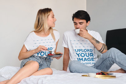 T-Shirt Mockup of a Couple Eating Breakfast in their Bedroom