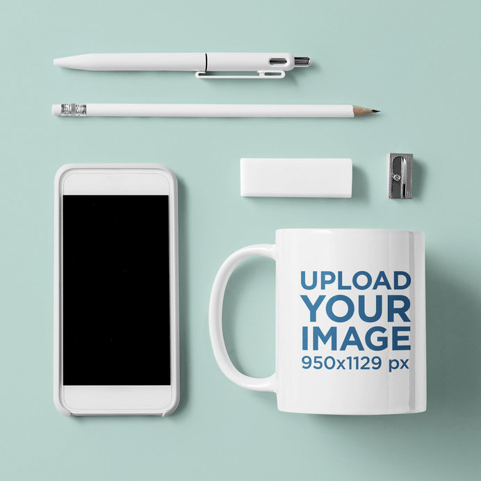 Mockup of an 11 oz Coffee Mug with a Phone and Some Office Supplies