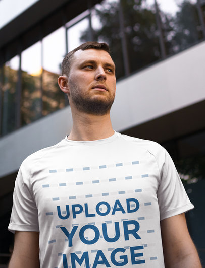 T-Shirt Mockup of a Serious Man Posing By a Building 