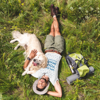 T-Shirt Mockup of a Man Lying on the Grass With His Dog 