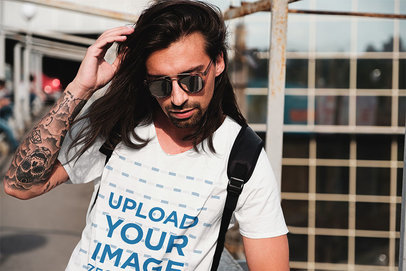 Mockup of a Long-Haired Man With an Arm Tattoo Wearing a V-Neck Tee 