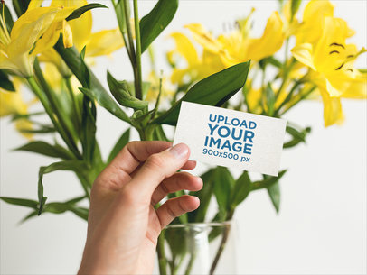 Business Card Mockup Held Next to Yellow Flowers