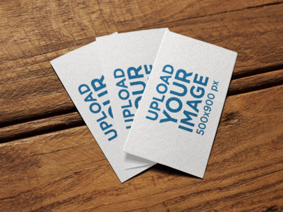 Three Business Cards Mockup Lying on a Wooden Surface