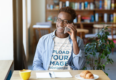 T-Shirt Mockup of a Young Man Making a Call While Studying 