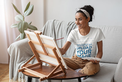 T-Shirt Mockup Featuring a Woman Painting at Home 