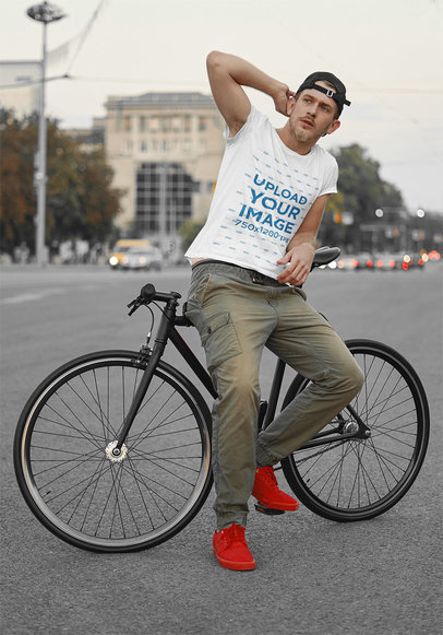 Basic Tee Mockup of a Man Posing With His Bike in the City 