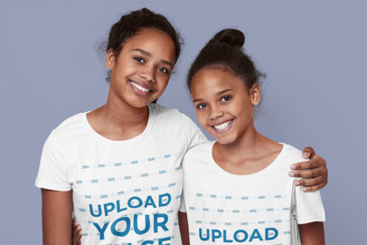 T-Shirt Mockup of Two Sisters Hugging in a Studio