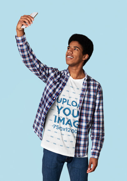 T-Shirt Mockup of a Young Man Taking a Selfie at a Studio 