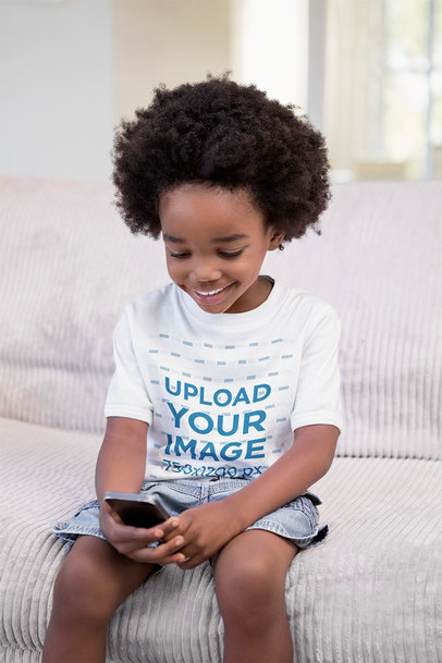 T-Shirt Mockup of a Happy Kid Using a Smartphone 